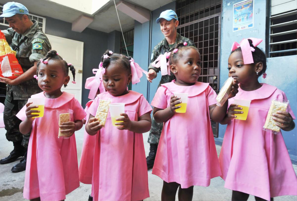 Brazilian UN peacekeepers distribute juice and crackers to students at the Immaculate Conception School February 6, 2013 in Port-au-Prince, Haiti. AFP PHOTO Thony BELIZAIRE (Photo credit should read THONY BELIZAIRE/AFP/Getty Images)