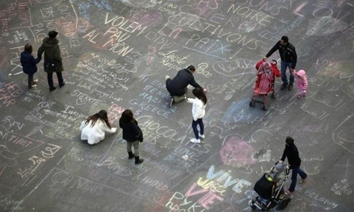 People write messages on the ground at Place de la Bourse, a square outside the Brussels stock exchange. Photograph: Kenzo Tribouillard/AFP/Getty Images