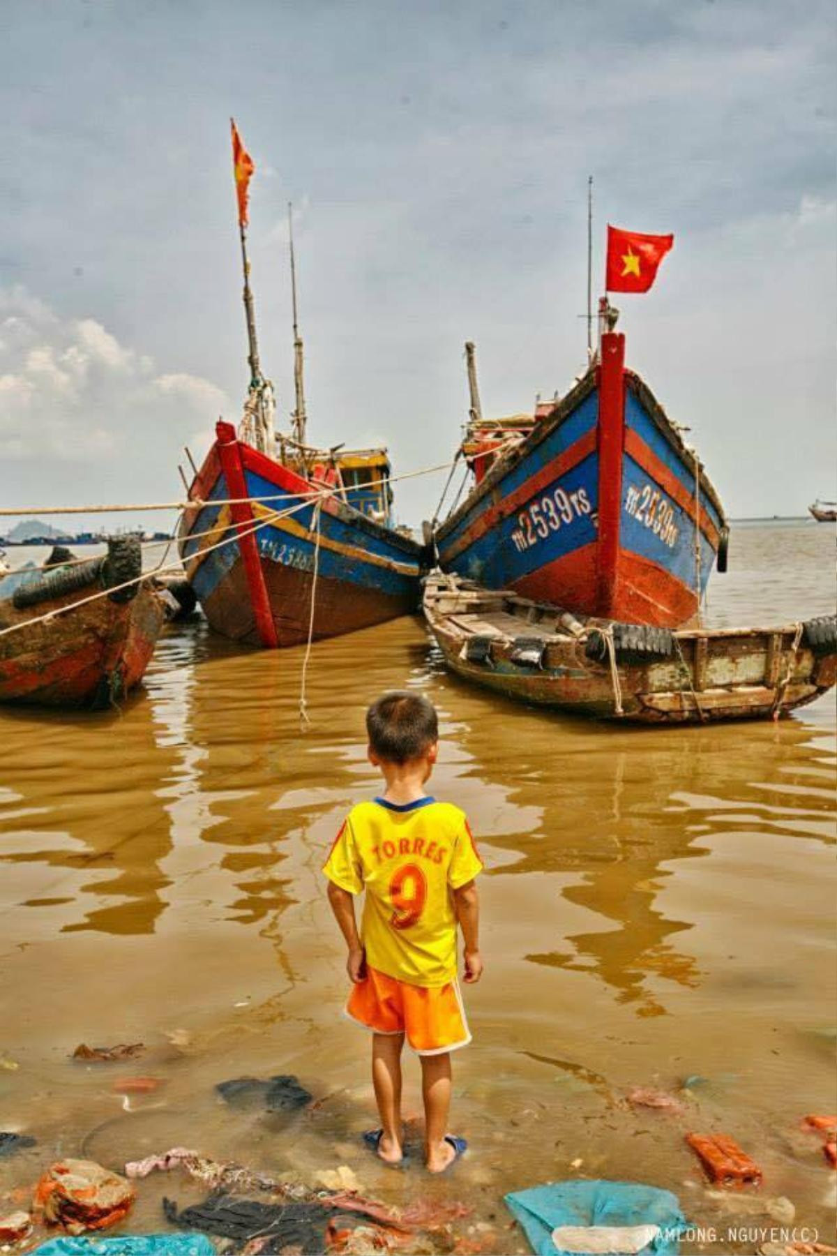 Trẻ em vui chơi quanh khu vực chứa đầy rác thải, trên mặt nước đục ngầu là những chiếc túi nilon.. 