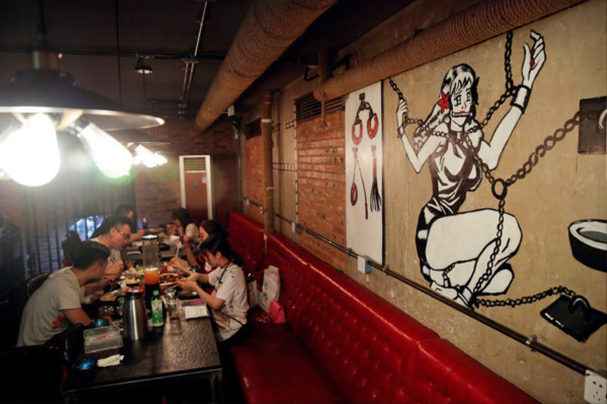 Customers eat a meal at Ke'er restaurant (Shell in English) in Beijing, China, May 26, 2016. With drinks served in breast-shaped cups and beers opened with bottle openers shaped like a wooden penis, the father and daughter team behind a Beijing S&M restaurant are encouraging customers to mix food with sex. Owner Lu Lu said business has been good since opening just under a year ago, with young Chinese streaming in to feast on seafood, such as lobster, under the gaze of mannequins wearing bondage gear. REUTERS/Kim Kyung-Hoon SEARCH "BEIJING SHELL" FOR THIS STORY. SEARCH "THE WIDER IMAGE" FOR ALL STORIES. EDITORIAL USE ONLY. NO RESALES. NO ARCHIVE.