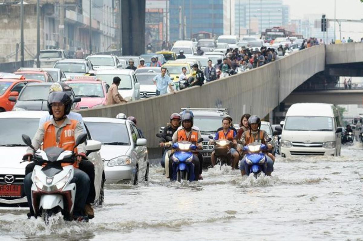 Nhiều người Bangkok phải rời ôtô và ra đứng trên cầu trong giai đoạn kẹt xe nghiêm vào giờ cao điểm ở thủ đô sáng 21/6 do nhiều đoạn đường bị tê liệt do ngập.