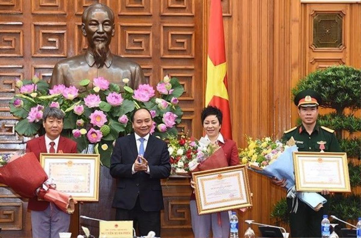 Thủ tướng trao Huân chương Lao động Hạng Nhất cho vận động viên Hoàng Xuân Vinh; trao Huân chương Lao động Hạng nhì cho Huấn luyện viên trưởng Đội tuyển bắn súng Việt Nam Nguyễn Thị Nhung và trao Huân chương Hữu nghị cho ông Park Chung Gun, chuyên gia bắn súng Hàn Quốc. Ảnh: chinhphu.vn