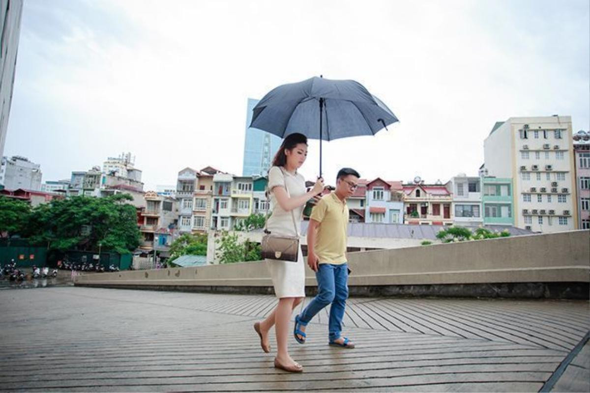 Tú Anh đội mưa bão di chuyển vào trong trường quay.