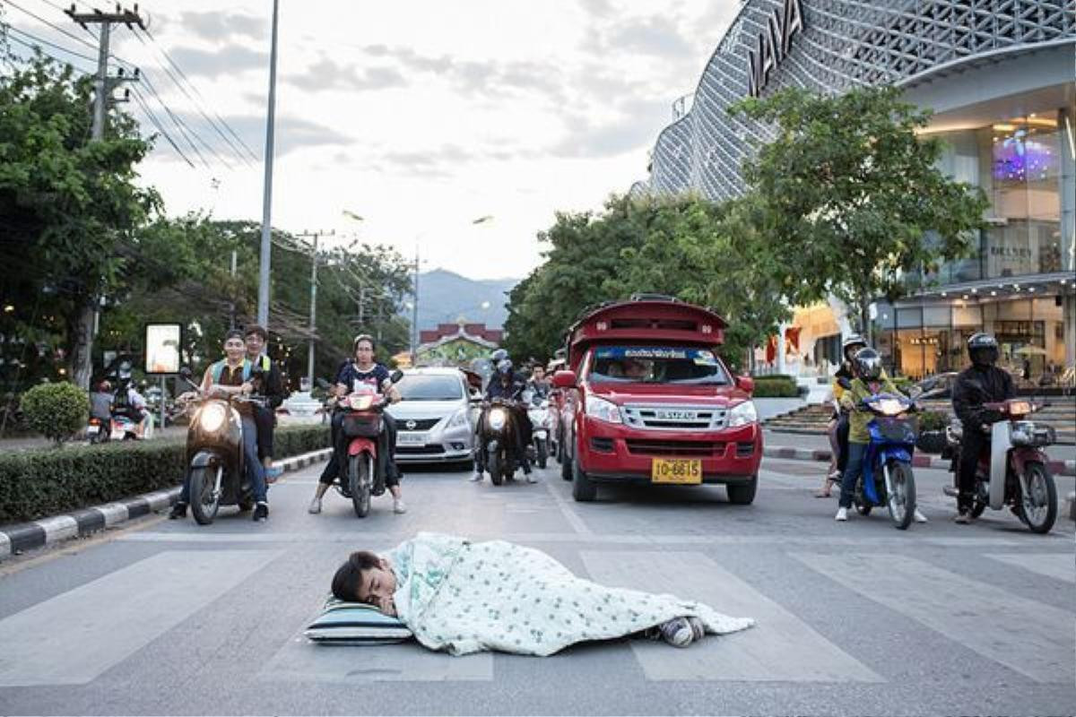 Bức ảnh chàng trai mang chăn, gối ra ngủ giữa đường.