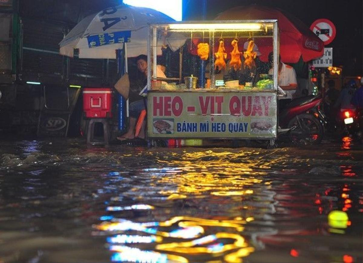 Một điểm bán thực phẩm bên đường Võ Nguyên Giáp bị nước bao vây. Theo chủ quầy hàng, vị trí anh đặt tủ kính để kinh doanh cao hơn mặt đường 50 cm, tuy nhiên, khu vực vẫn bị nước ngập suốt 2 giờ.