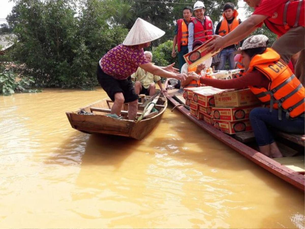 Người dân đội mưa đi nhận hàng cứu trợ nhưng khó khăn vẫn chờ đợi họ ở phía trước khi nhiều tài sản bị thiệt hại trong mưa lũ.