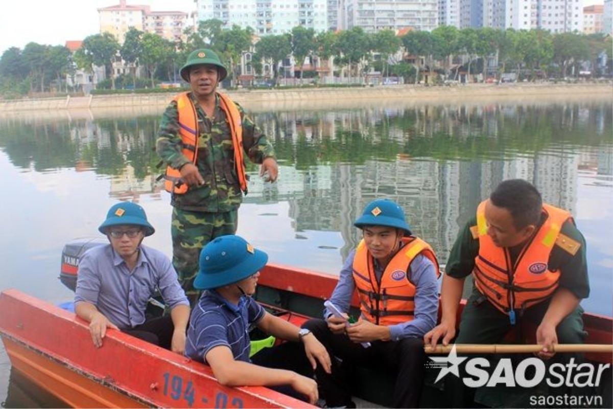 Lực lượng chức năng túc trực để vớt xác cá và rác thải, làm sạch mặt hồ.