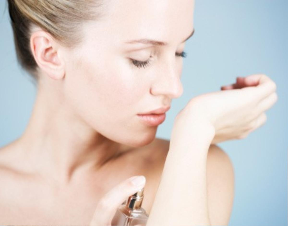 A young woman applying perfume