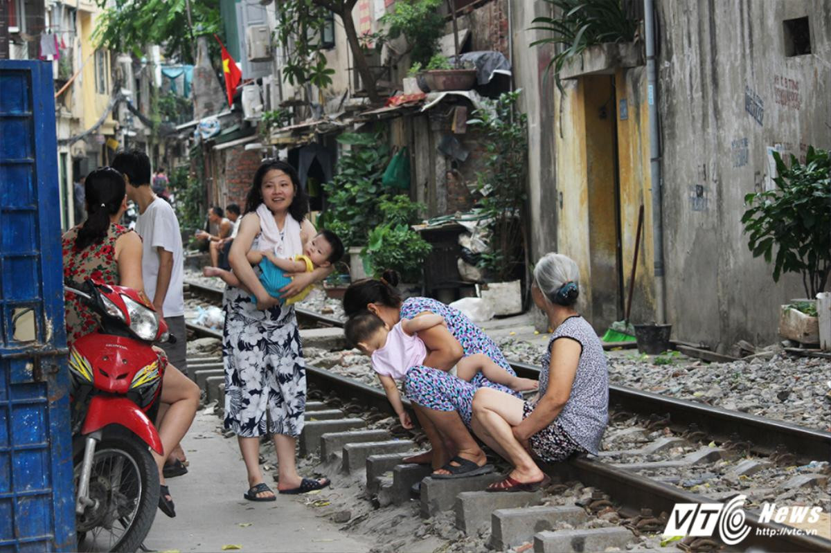 Thản nhiên bế cháu ngồi trên đường ray tán gẫu, thách thức tử thần Ảnh 2