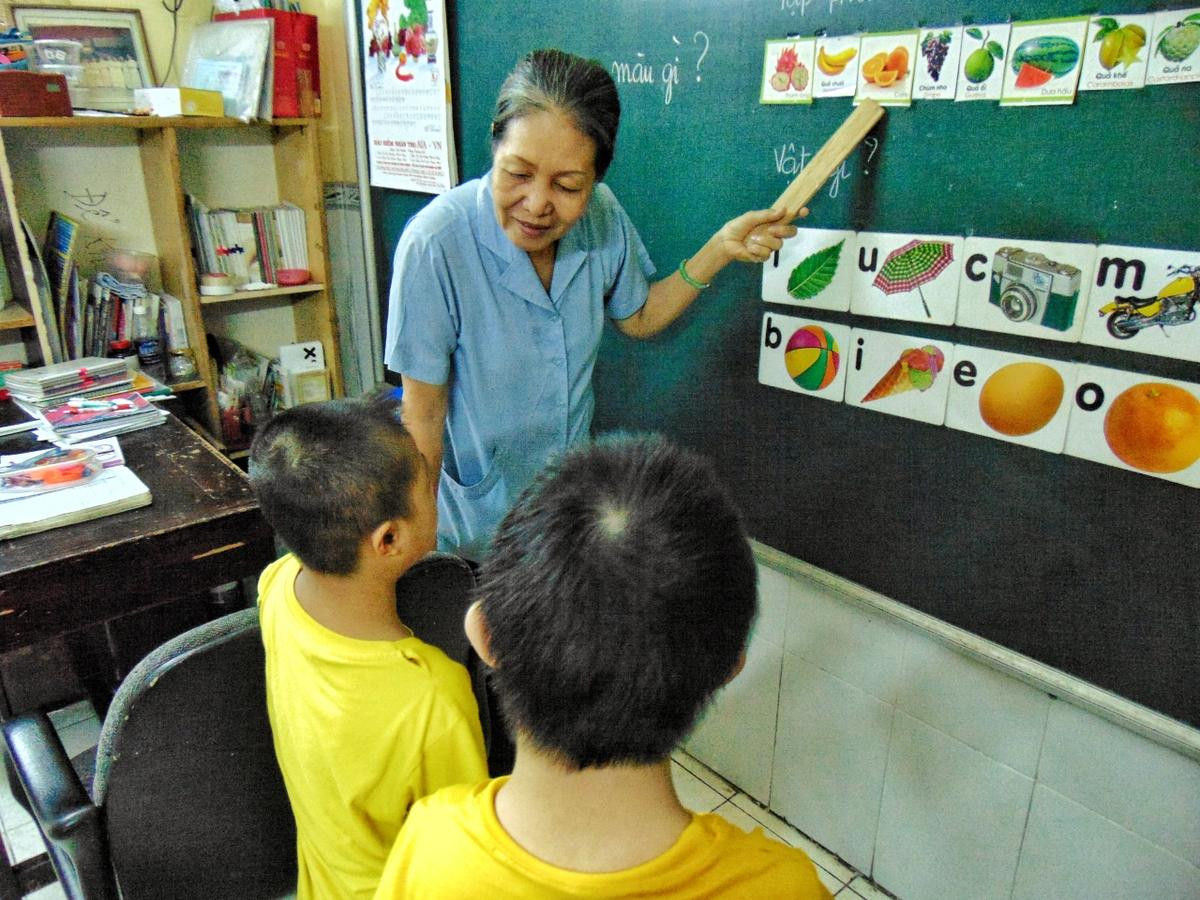 Cô Đỗ Thị Nga, một người đã gắn bó với trung tâm từ ngày đầu thành lập, kiên nhẫn dạy dỗ các em từ những điều nhỏ nhặt nhất.