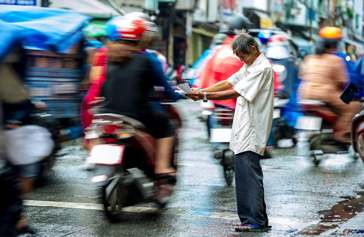 Xúc động trước hình ảnh cụ ông bán vé số mếu máo giữa dòng người tấp nập 'chạy mưa' ở Sài Gòn Ảnh 1