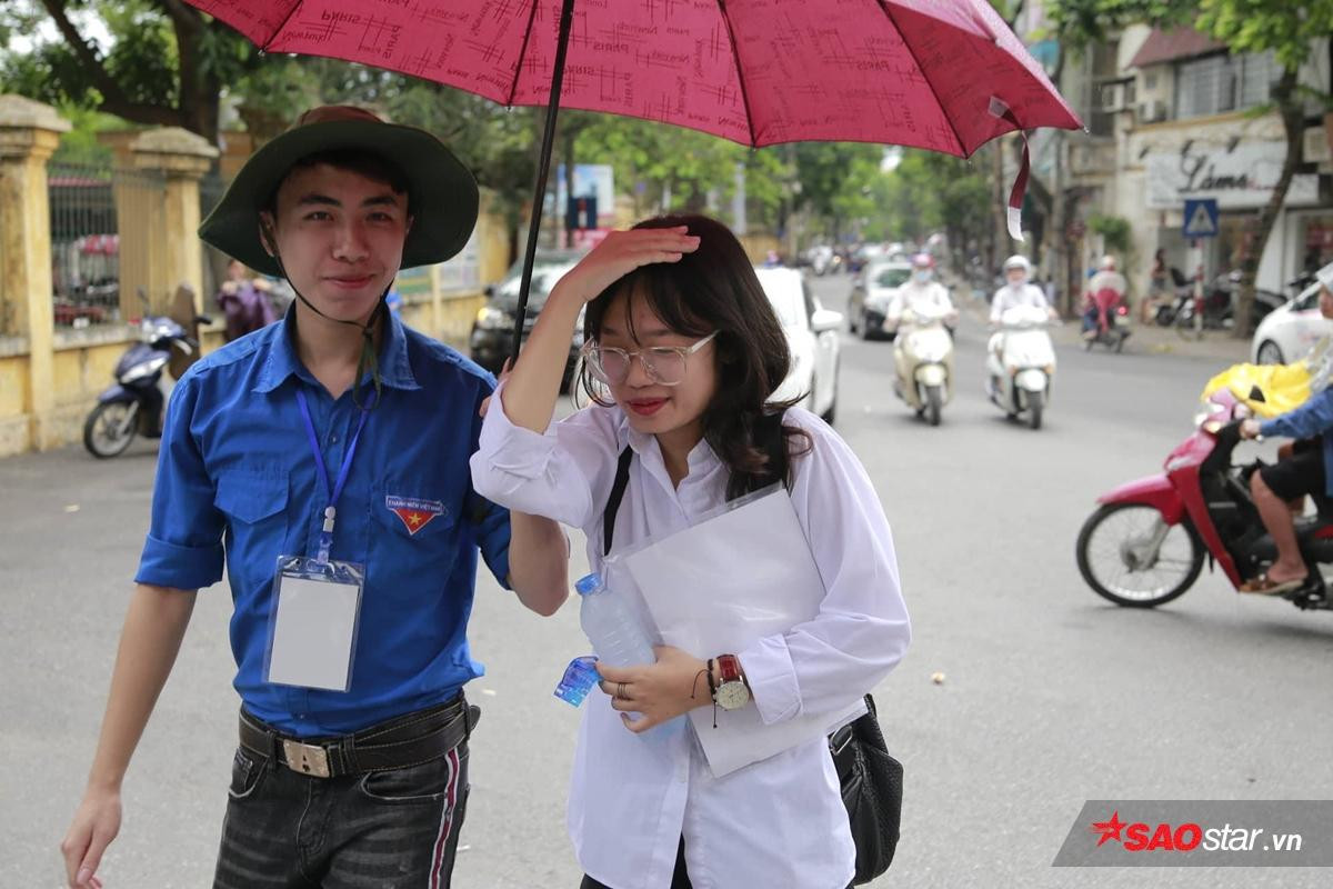 Hà Nội đổ mưa như càng chứng tỏ tấm lòng đẹp của sinh viên tình nguyện: Mặc người ướt vẫn nhường ô, áo mưa cho sĩ tử dự thi Ảnh 2