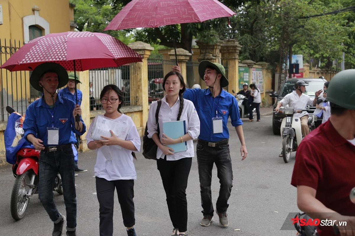 Hà Nội đổ mưa như càng chứng tỏ tấm lòng đẹp của sinh viên tình nguyện: Mặc người ướt vẫn nhường ô, áo mưa cho sĩ tử dự thi Ảnh 1