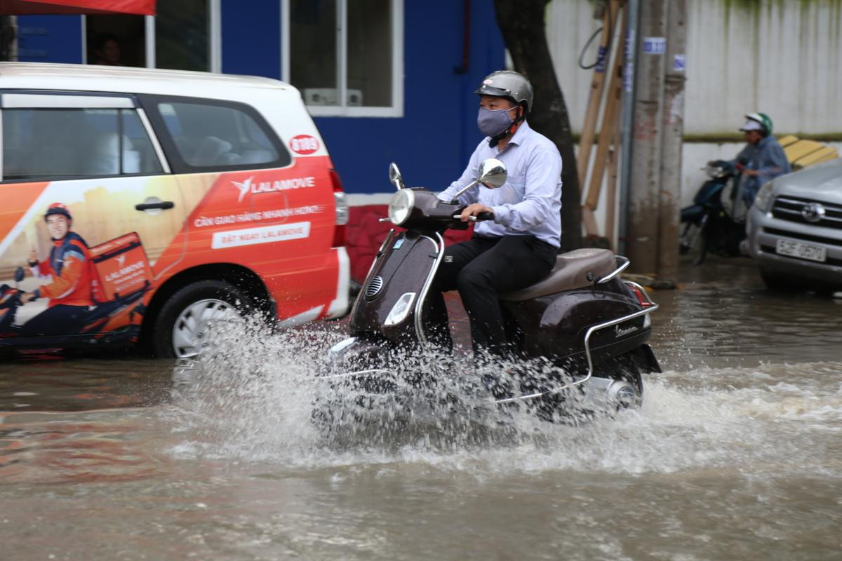 Phố nhà giàu ở Sài Gòn ngập nặng, học sinh được cõng trên lưng cha mẹ để rẽ nước về nhà Ảnh 1