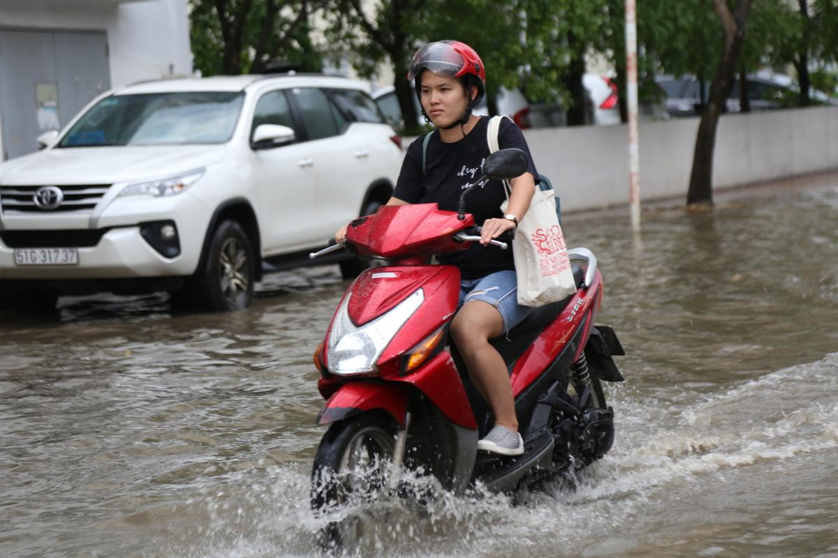 Phố nhà giàu ở Sài Gòn ngập nặng, học sinh được cõng trên lưng cha mẹ để rẽ nước về nhà Ảnh 4