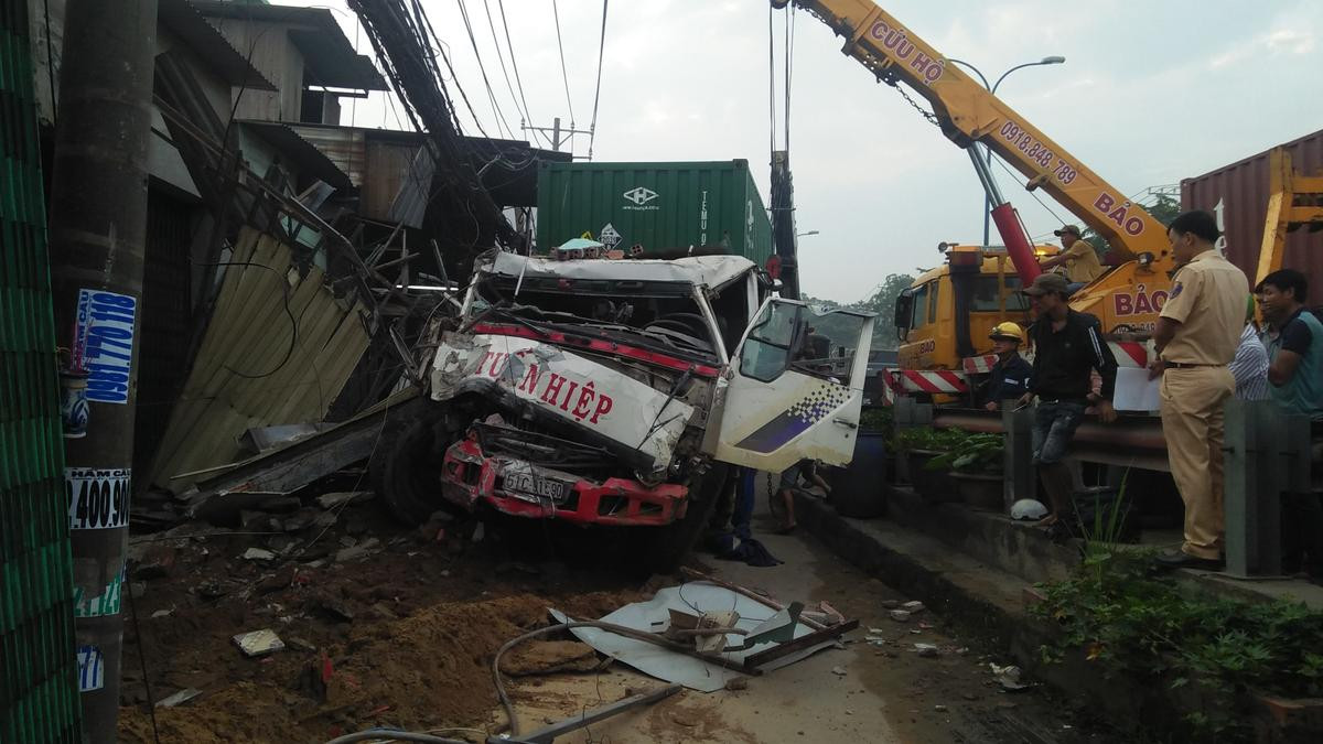 Container mất lái lao lên vỉa hè tông hàng loạt nhà dân, tài xế mắc kẹt trong cabin Ảnh 1