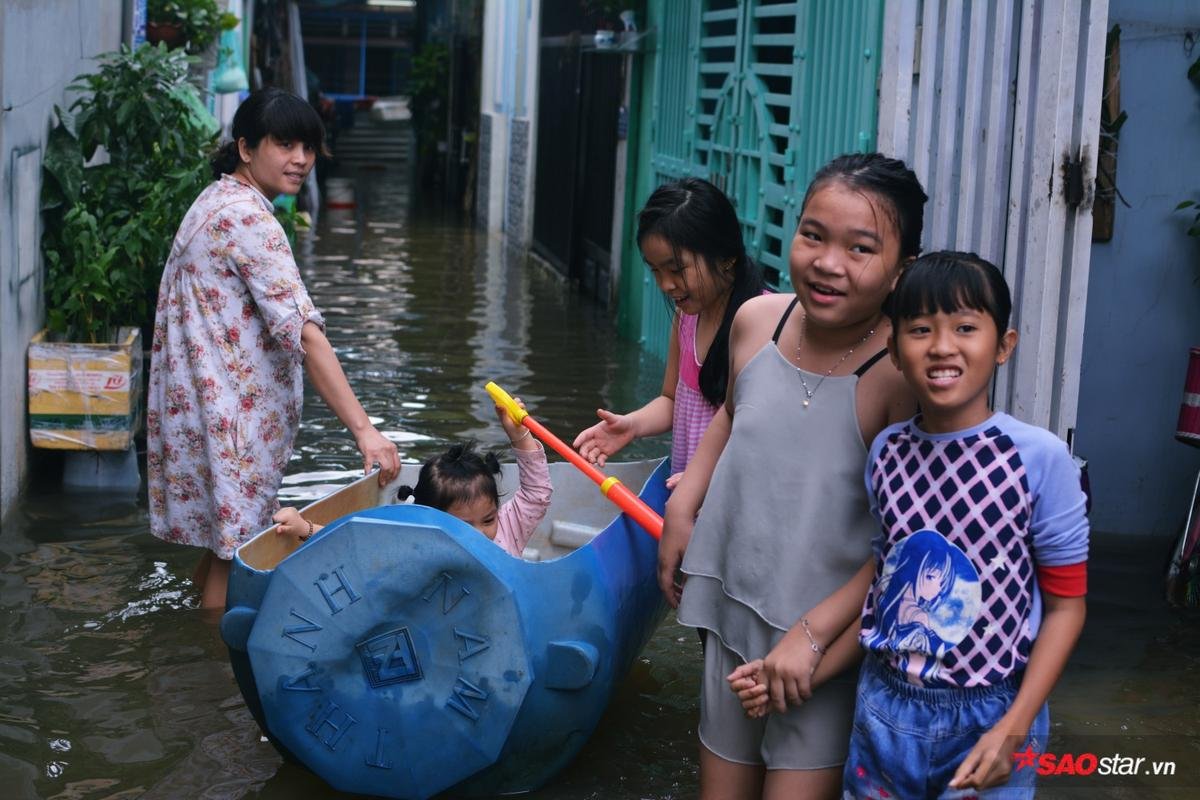 Mưa ngập lịch sử ở TP.HCM: Người dân kết bè thả ra đường, thích thú túm tụm chụp ảnh vui chơi giữa biển nước Ảnh 9