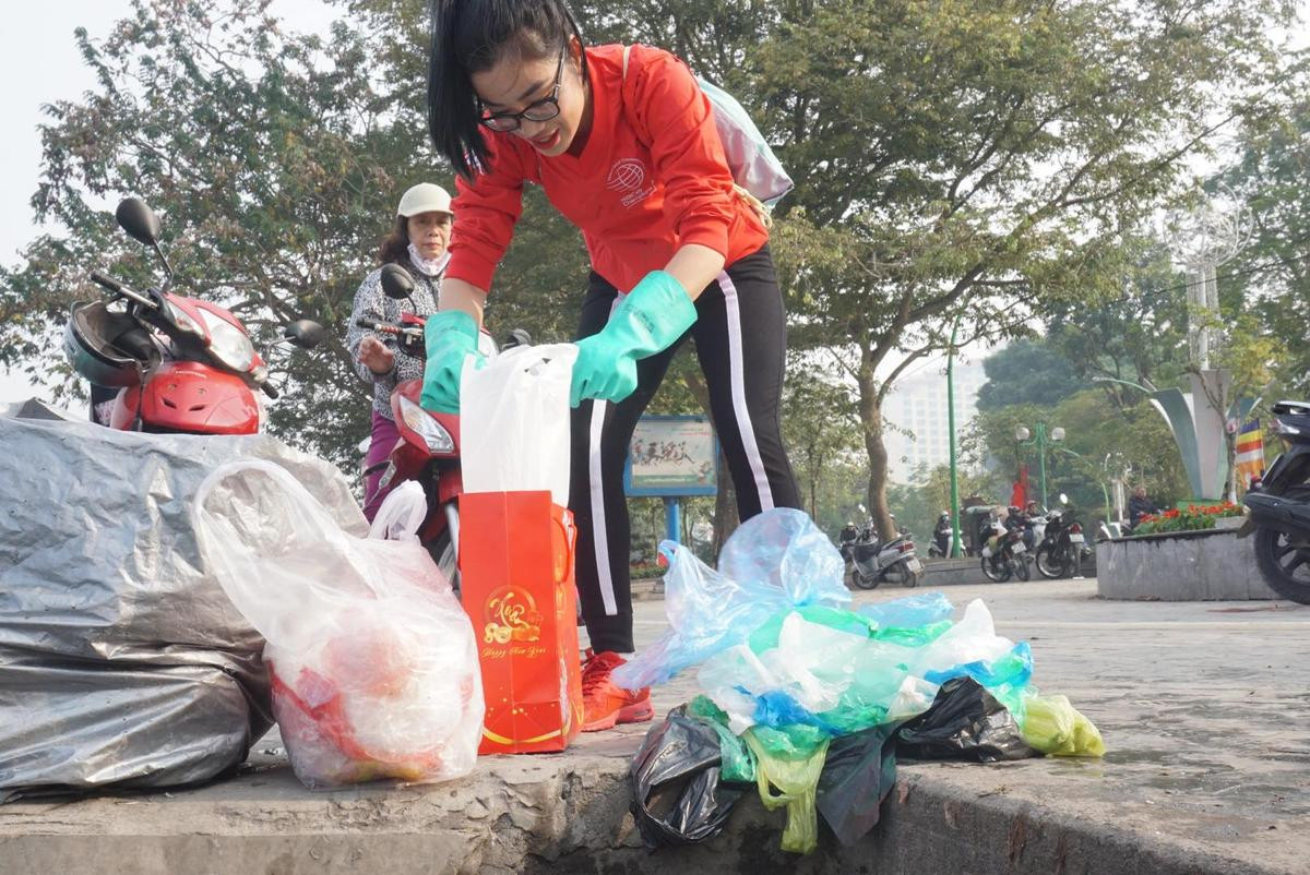 Bất ngờ với hình ảnh người đàn ông Nhật lặng lẽ đứng xin rác ở hồ Tây trong ngày ông Công ông táo Ảnh 1