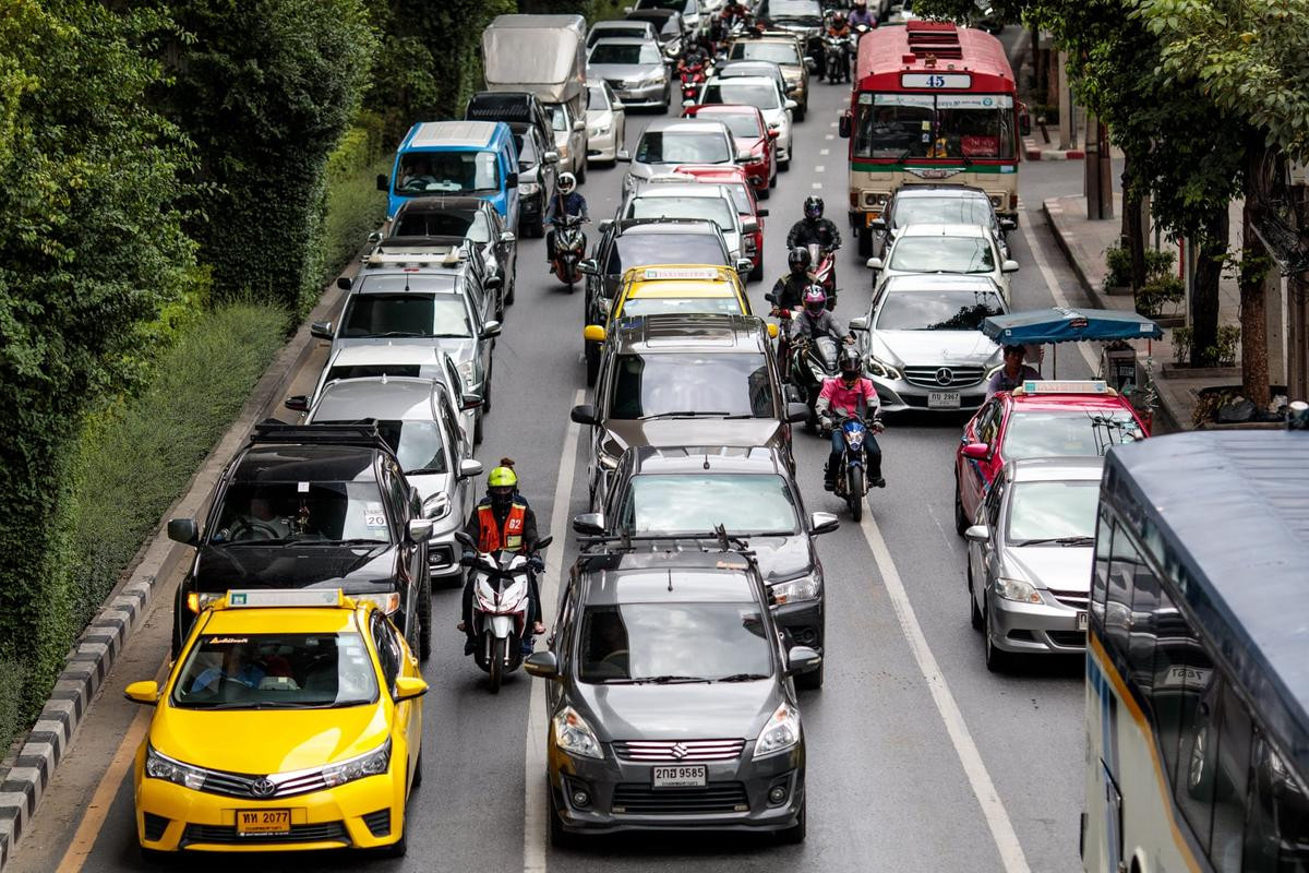 Một tài xế xe ôm truyền thống đang chở khách trên đường vào giờ cao điểm ở Bangkok. Ảnh: Jack Taylor.