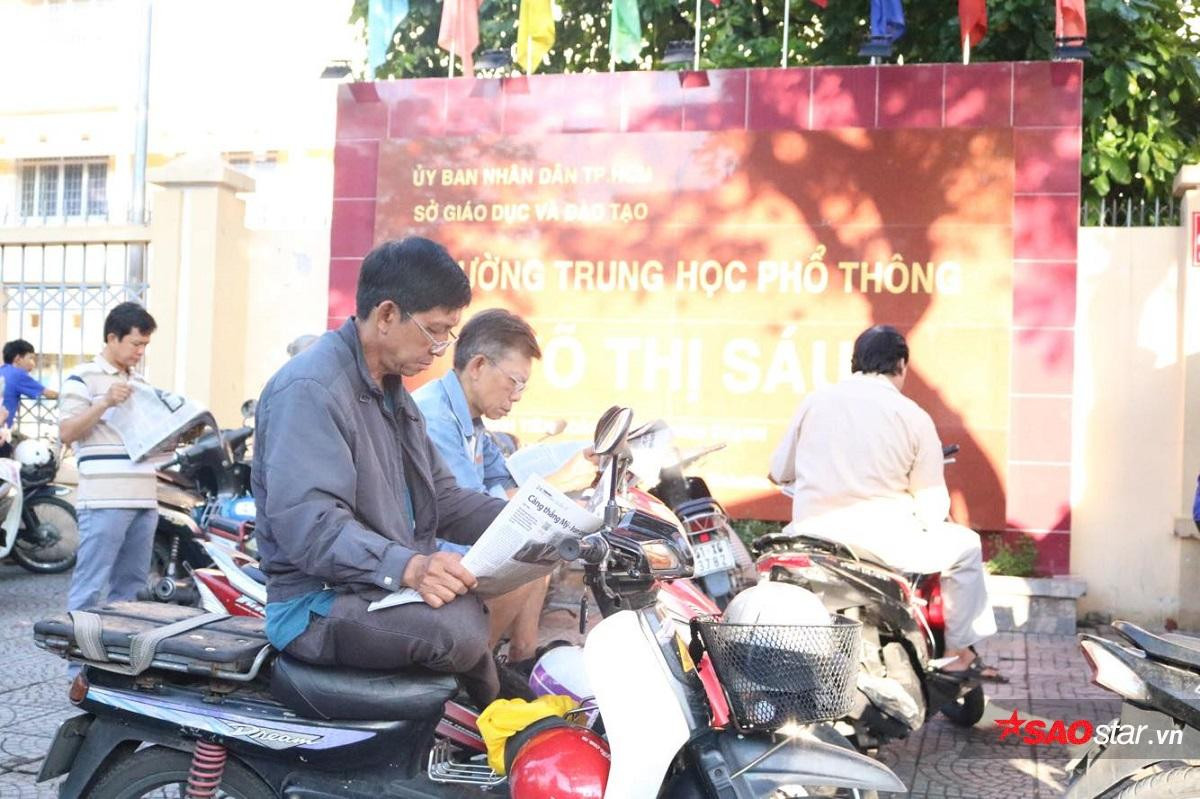 Kỳ thi THPT Quốc gia 2019: Phụ huynh tranh thủ đọc báo, đội nắng chờ con trong ngày thi đầu tiên Ảnh 6