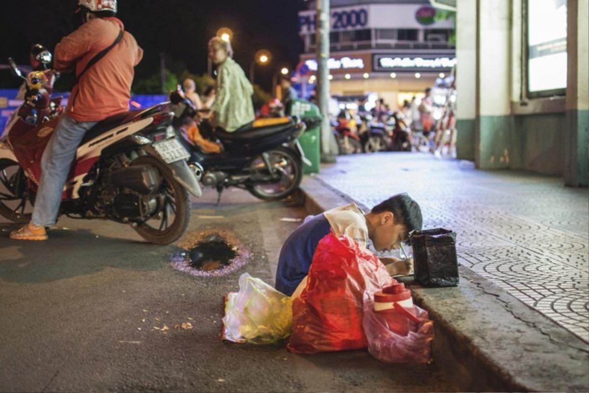 Bức ảnh mẹ dạy con học bài ngay trên vỉa hè Sài Gòn náo nhiệt khiến nhiều người lay động Ảnh 4