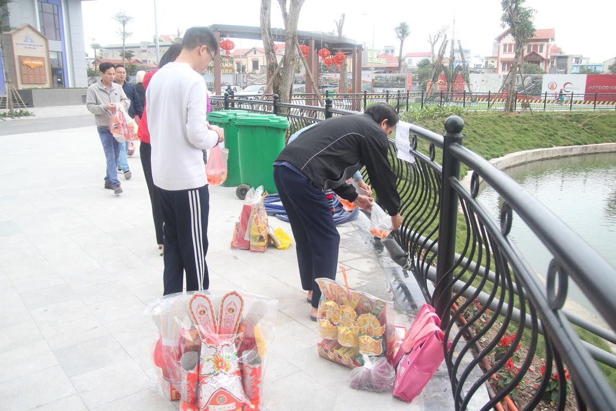 Người Hà Nội thích thú thả cá bằng ‘cầu trượt’ xuống hồ tiễn ông Công ông Táo về trời Ảnh 2