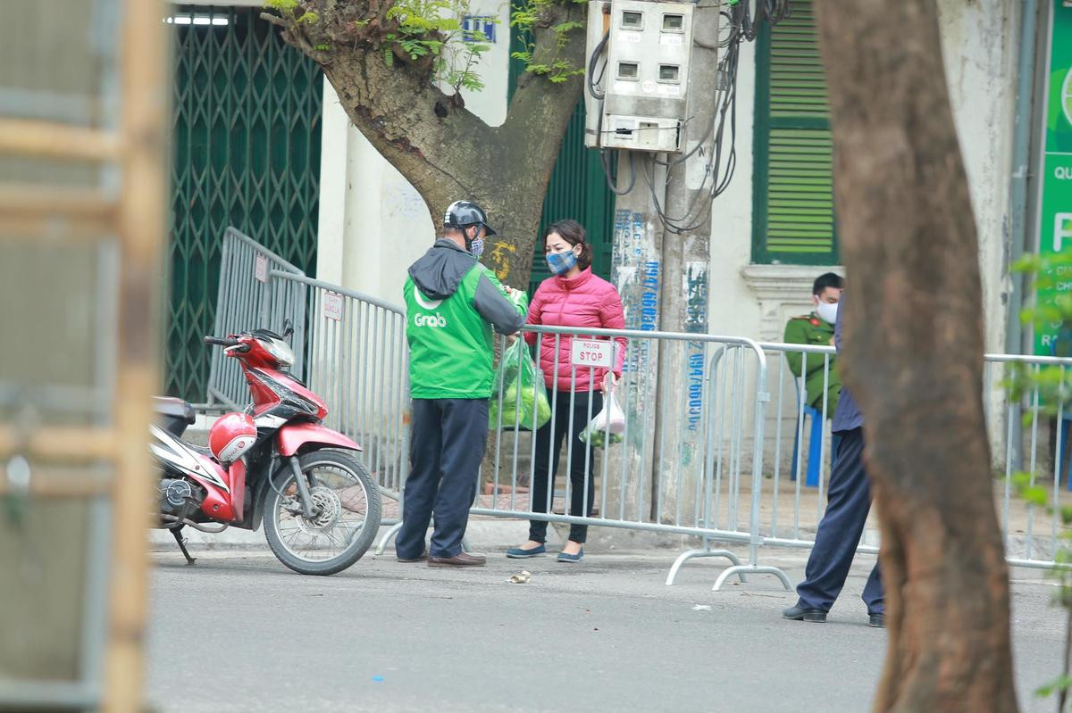 Lập chốt cách ly phố Trúc Bạch sau vụ cô gái nhiễm COVID-19: Cửa hàng đóng cửa, người dân nhận tiếp tế từ người thân bên ngoài Ảnh 2