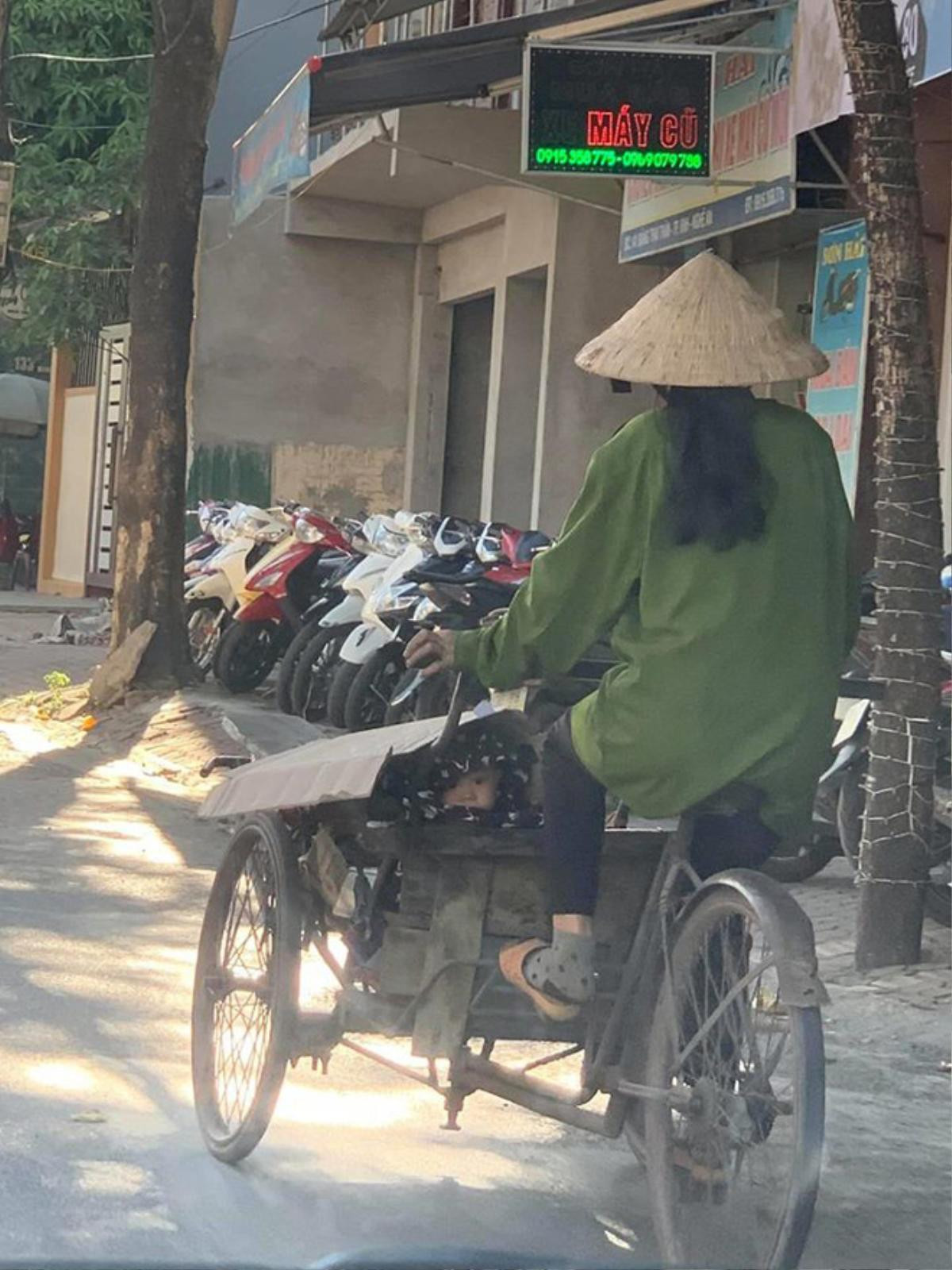 Hình ảnh em bé lấp ló trong chiếc xe hàng cũ kỹ của mẹ giữa tiết trời nóng nực khiến nhiều người thương cảm Ảnh 1