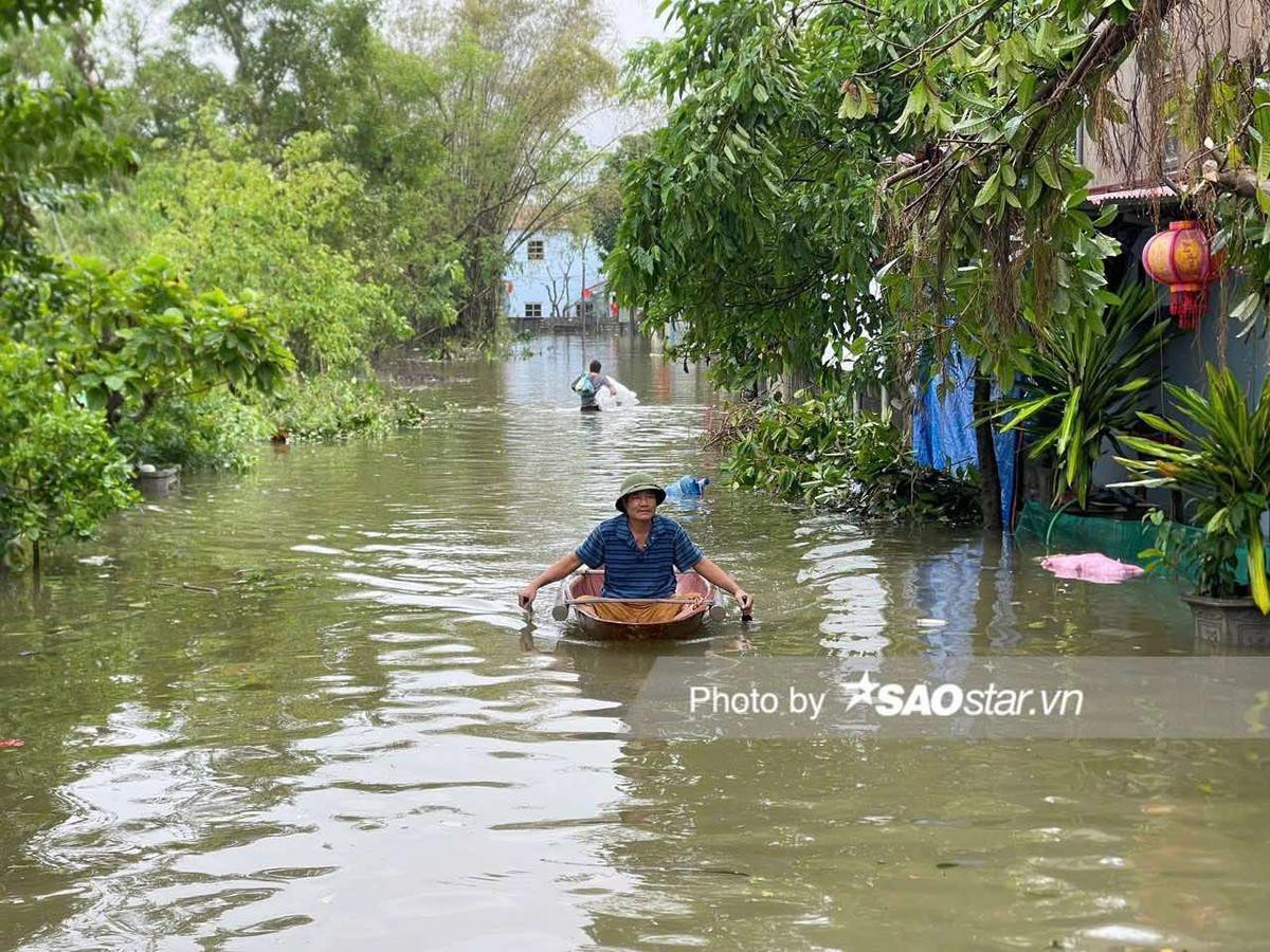 Người dân Chương Mỹ vội vã chạy khỏi lũ sâu ngang ngực bằng thuyền, xe máy kéo Ảnh 1