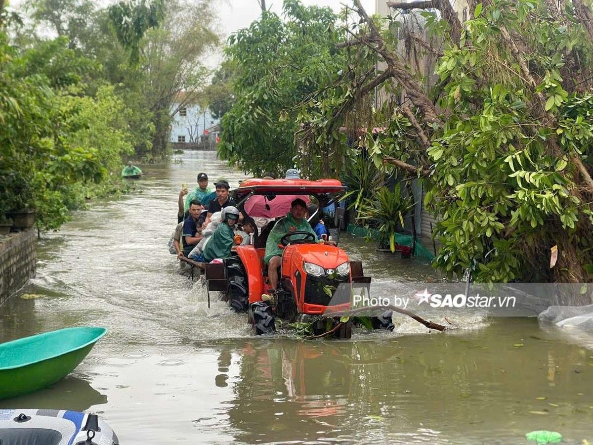 Người dân Chương Mỹ vội vã chạy khỏi lũ sâu ngang ngực bằng thuyền, xe máy kéo Ảnh 6