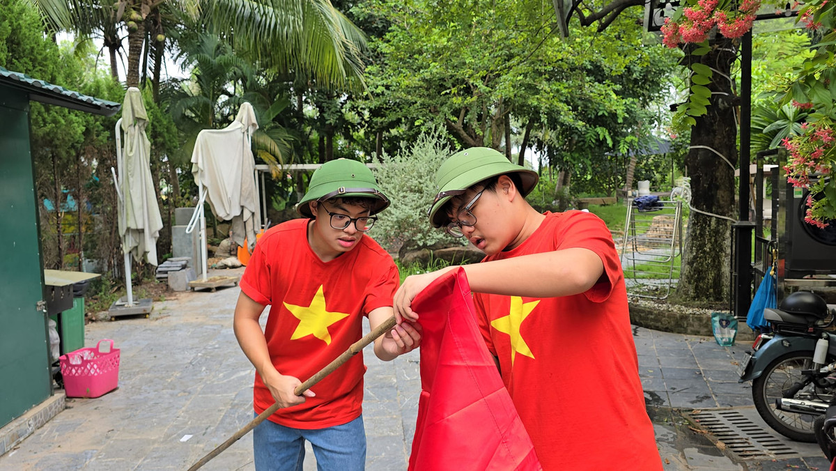 Hình ảnh hai con trai Xuân Bắc đội mũ cối, mặc áo cờ đỏ sao vàng