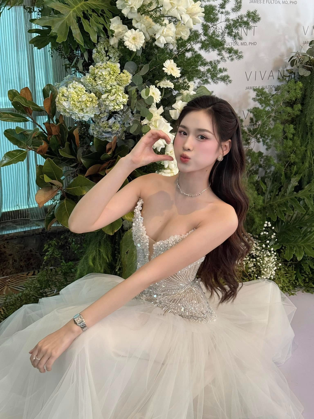 Đỗ Thị Hà khoác lên mình một chiếc váy dạ hội màu trắng tinh khôi, thiết kế cúp ngực tôn lên bờ vai mảnh mai cùng vóc dáng thon gọn. Phần thân váy được đính kết những viên đá lấp lánh, tạo hiệu ứng lộng lẫy mỗi khi nàng hậu di chuyển. Kết hợp với kiểu tóc xoăn nhẹ buông hờ và lớp trang điểm trong veo, nàng hậu xứ Thanh toát lên sự sang trọng nhưng vẫn giữ được nét trong trẻo đặc trưng.
