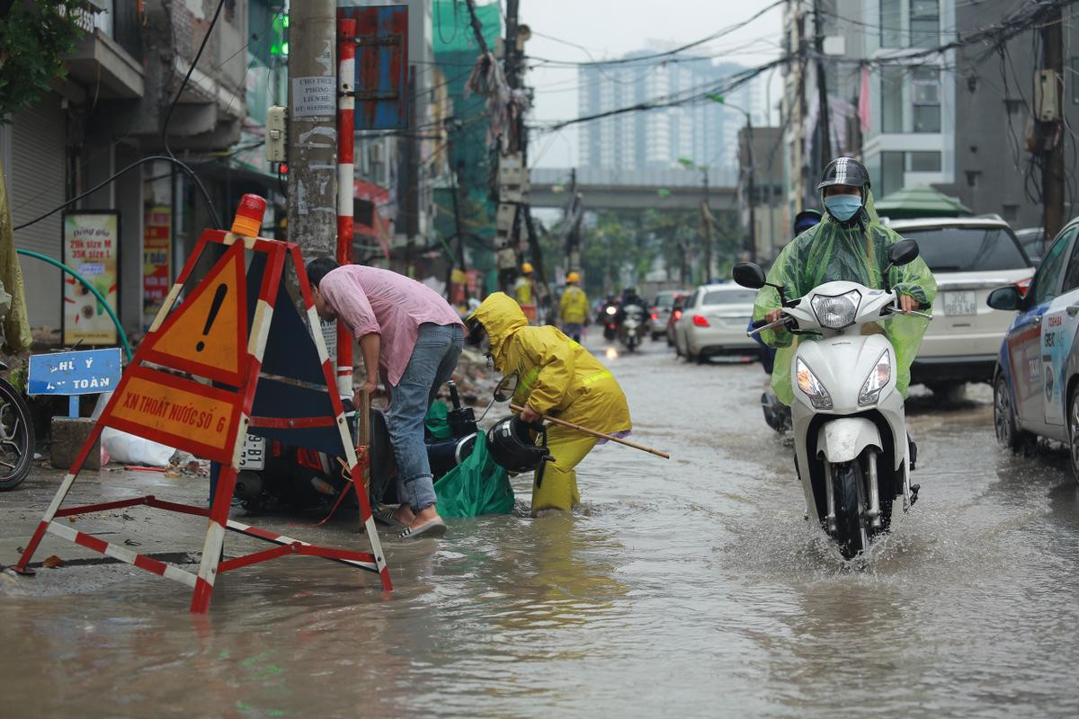 Mưa lớn khiến nhiều tuyến đường Hà Nội chìm trong 'biển nước', người đi xe máy ngã lăn ra đường Ảnh 12