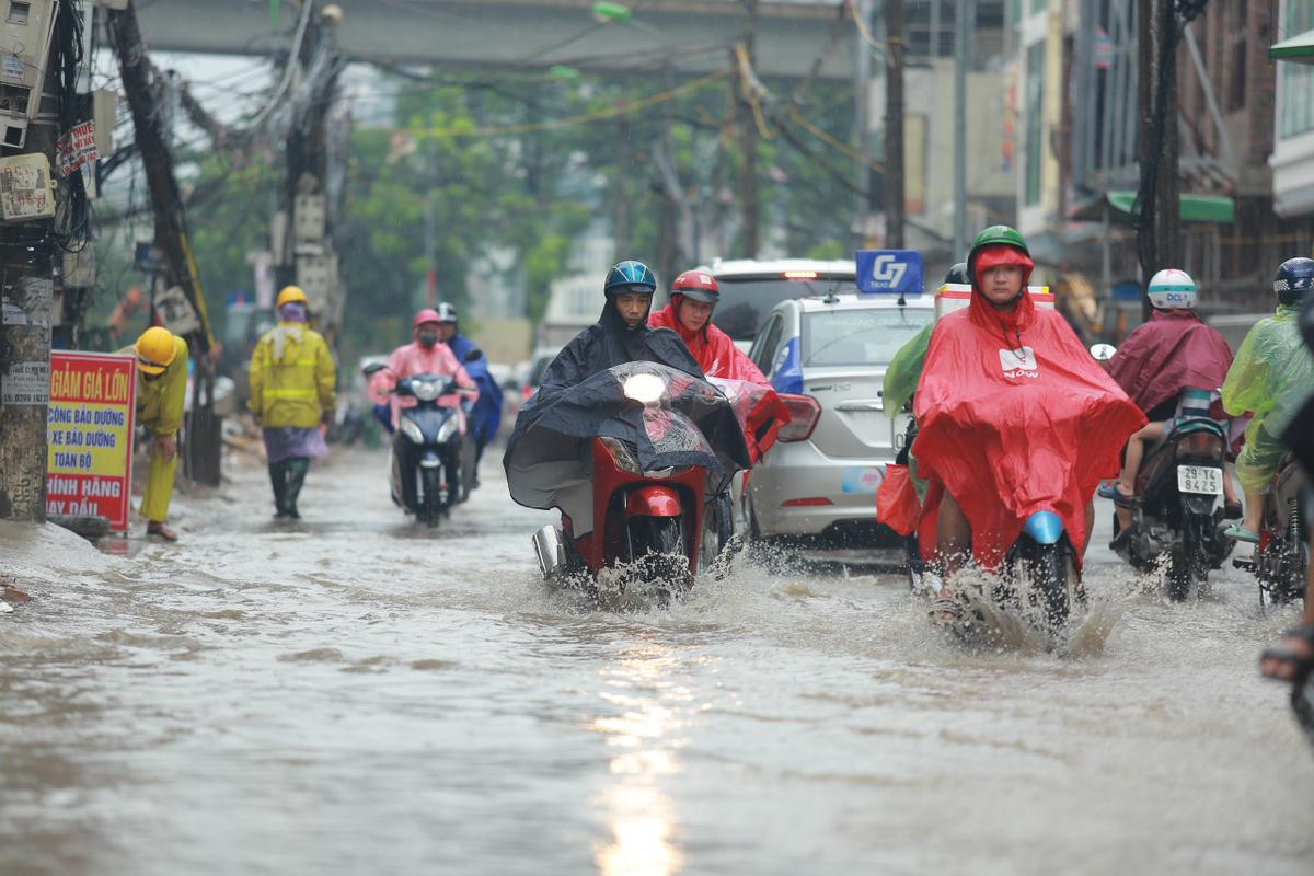 Mưa lớn khiến nhiều tuyến đường Hà Nội chìm trong 'biển nước', người đi xe máy ngã lăn ra đường Ảnh 4