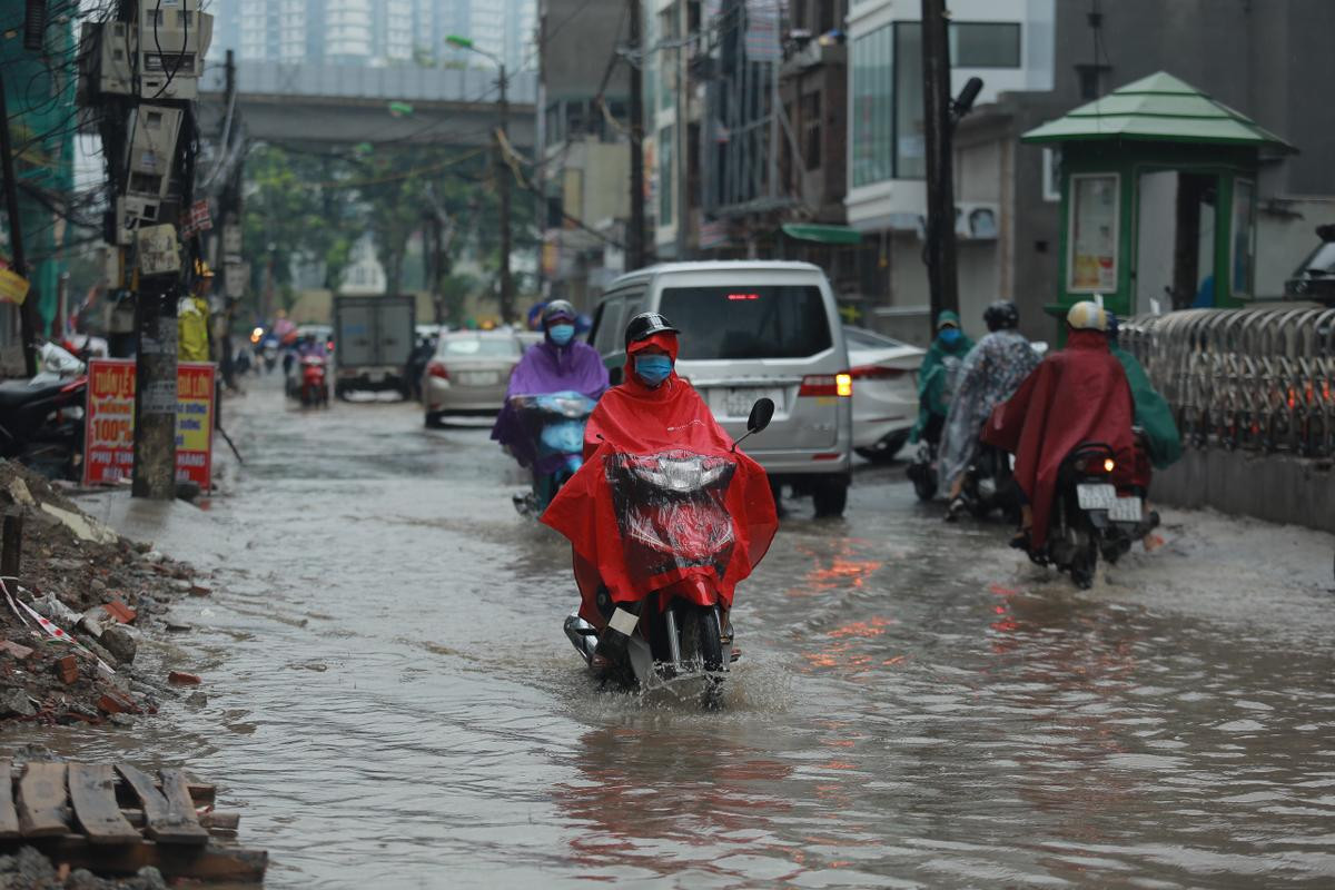 Mưa lớn khiến nhiều tuyến đường Hà Nội chìm trong 'biển nước', người đi xe máy ngã lăn ra đường Ảnh 1