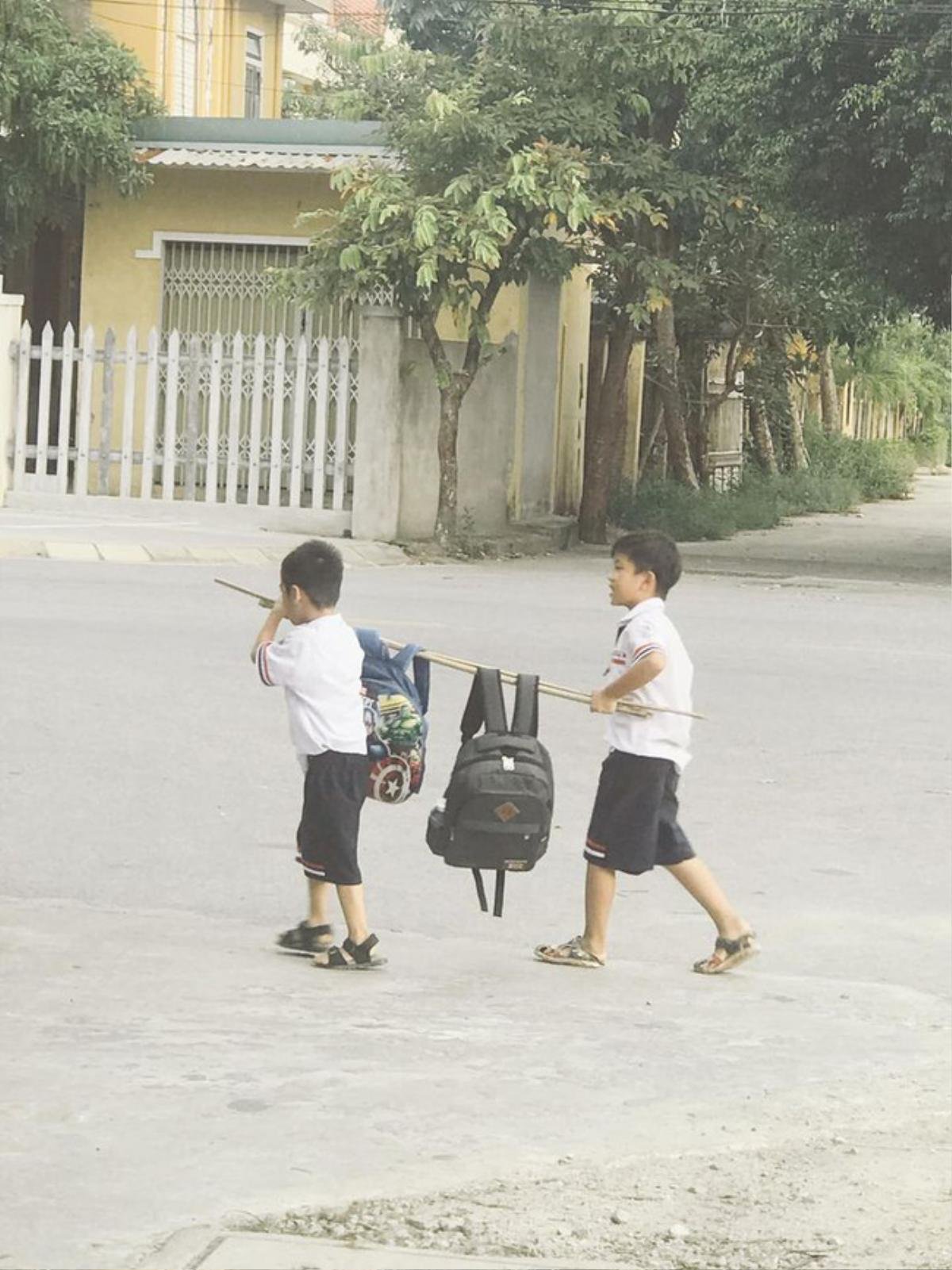 Hình ảnh hai cậu học trò vui vẻ trở về nhà sau giờ tan học, trên vai khiêng một thứ đặc biệt khiến dân mạng tấm tắc khen ngợi Ảnh 2