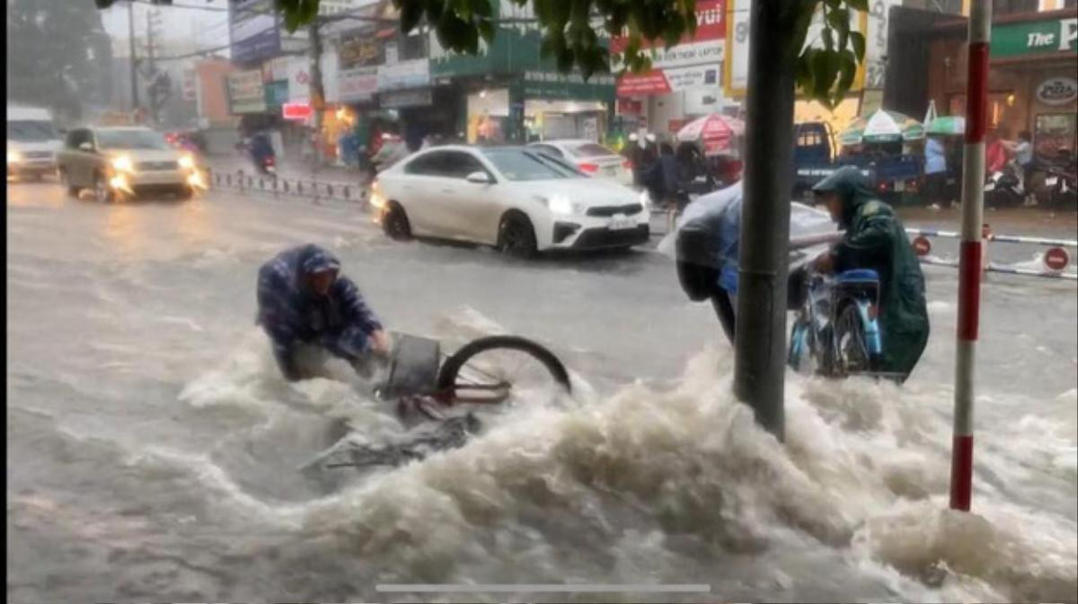 Bất chấp dòng nước chảy xiết trong cơn mưa lớn để đạp xe về nhà, nhóm học sinh ngã nhào xuống đường khiến nhiều người thót tim Ảnh 3