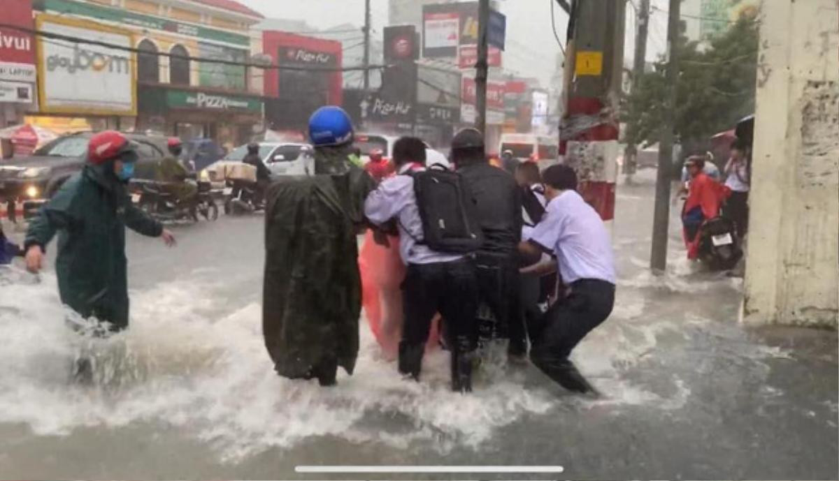 Bất chấp dòng nước chảy xiết trong cơn mưa lớn để đạp xe về nhà, nhóm học sinh ngã nhào xuống đường khiến nhiều người thót tim Ảnh 4