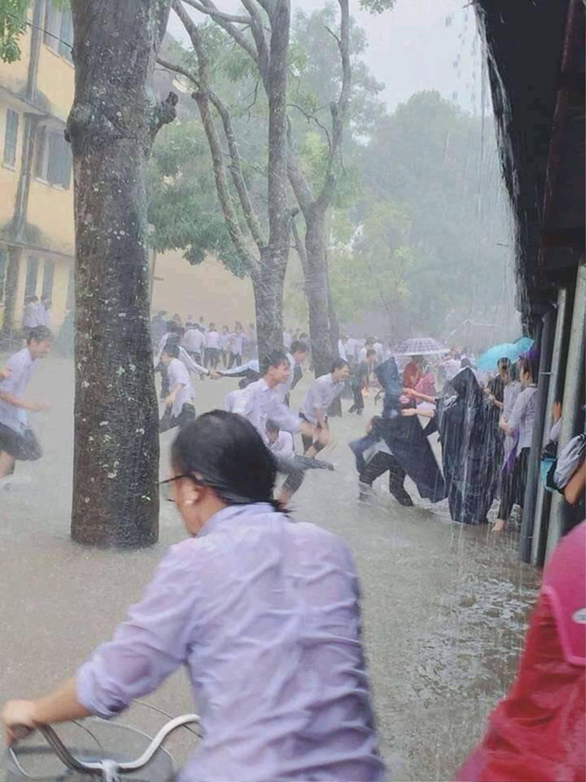 Bất chấp thời tiết bão bùng, nước mưa ngập đầu gối, các cô cậu học trò mặc sức vui đùa khiến nhiều người lo lắng Ảnh 1