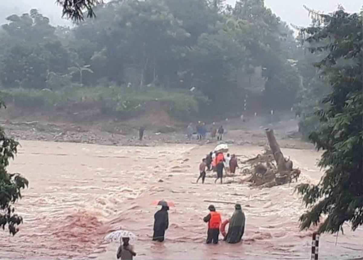 Lực lượng biên phòng cùng người dân đưa sản phụ qua cầu tràn ngập nước lũ đi sinh Ảnh 1