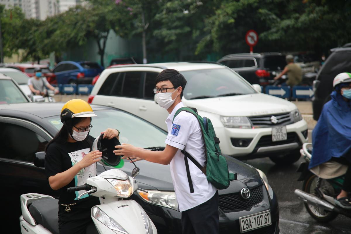 Sáng sớm mưa như trút nước, phụ huynh Hà Nội đội mưa đưa con đi thi vào lớp 10 Ảnh 3