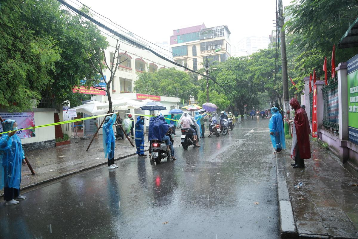 Hà Nội: Phụ huynh đội mưa đưa con đi thi, phải về lấy quần áo gửi đến phòng thi cho con thay Ảnh 1