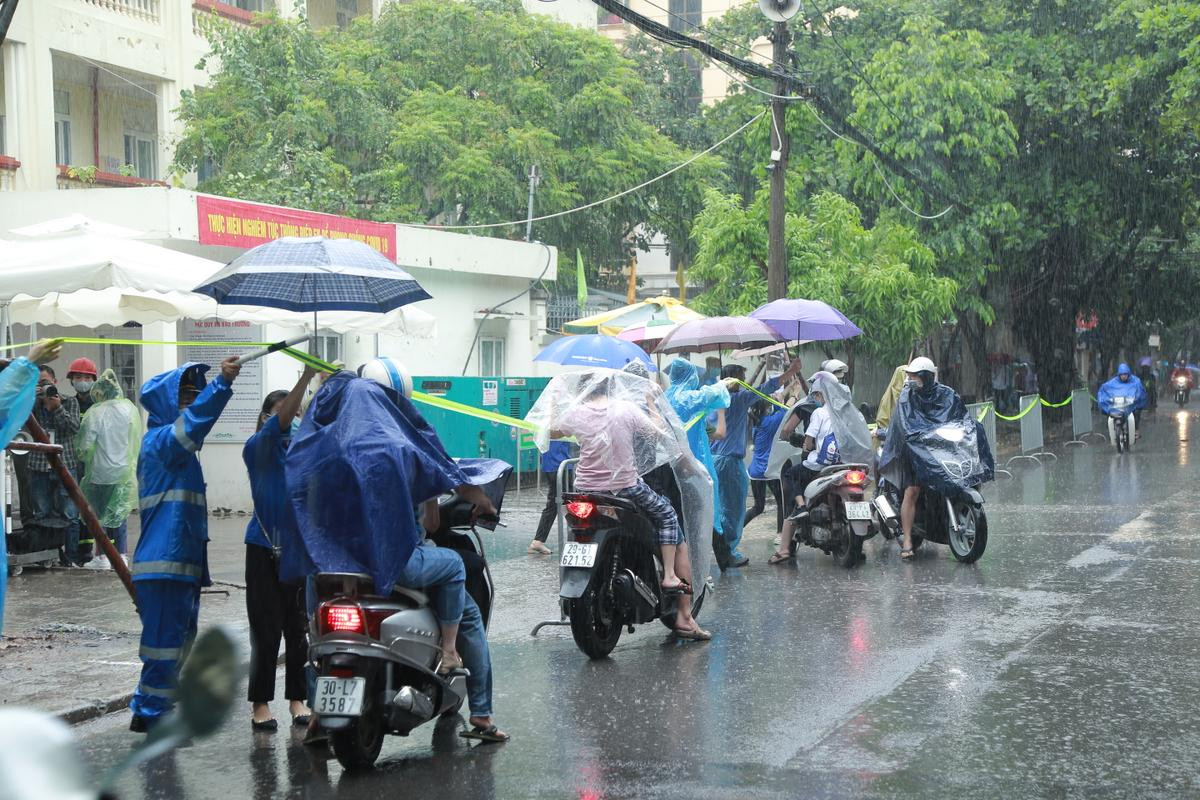 Hà Nội: Phụ huynh đội mưa đưa con đi thi, phải về lấy quần áo gửi đến phòng thi cho con thay Ảnh 3