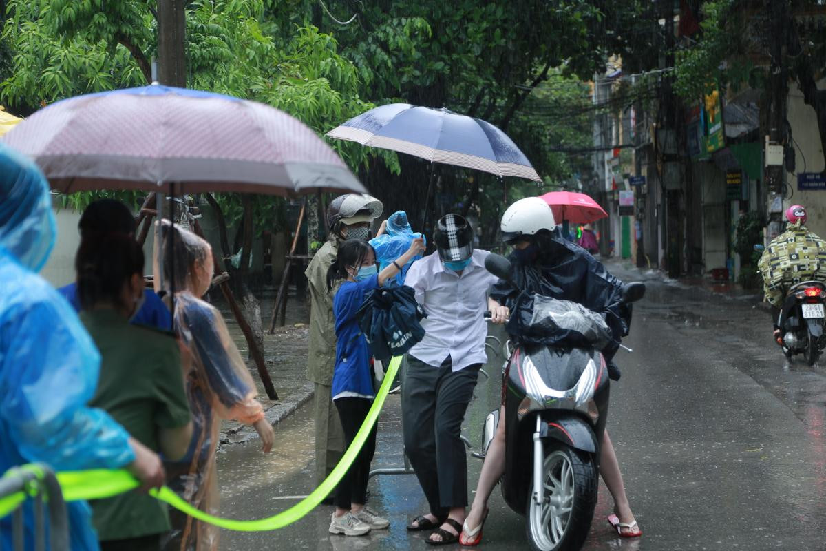 Hà Nội: Phụ huynh đội mưa đưa con đi thi, phải về lấy quần áo gửi đến phòng thi cho con thay Ảnh 4