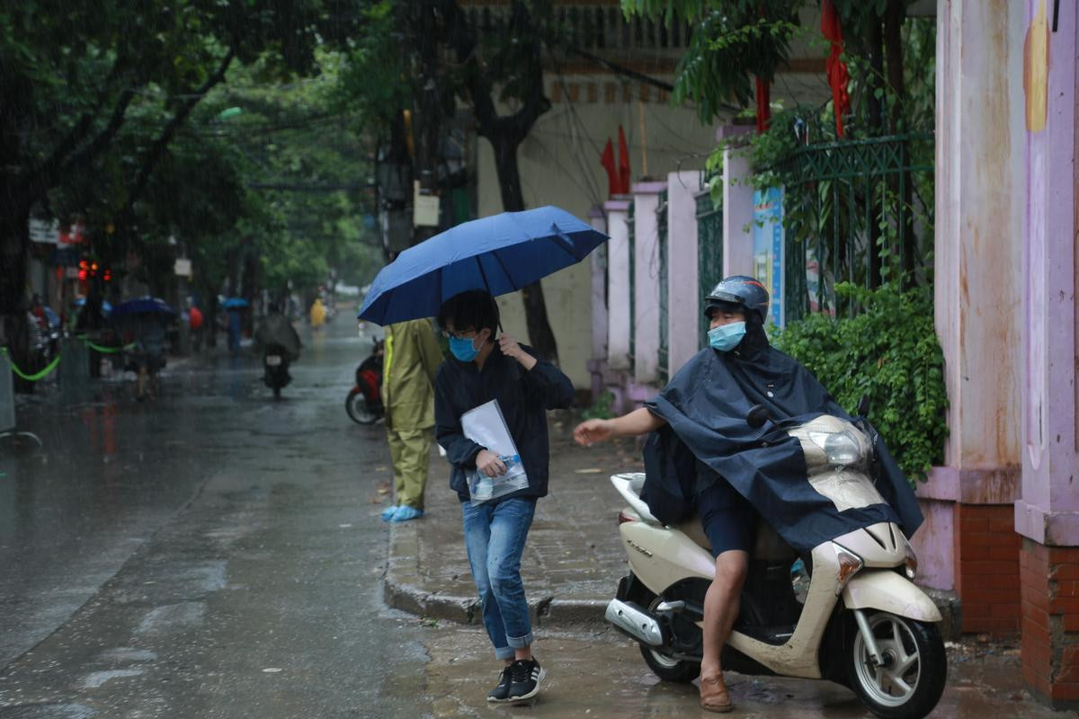 Hà Nội: Phụ huynh đội mưa đưa con đi thi, phải về lấy quần áo gửi đến phòng thi cho con thay Ảnh 5