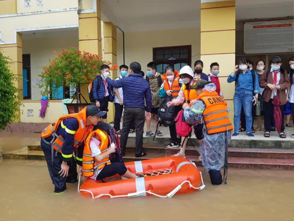 Lực lượng chức năng dùng xuồng hơi giải cứu hàng trăm học sinh kẹt trong trường bị nước lũ bao vây Ảnh 2