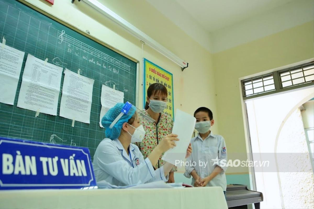 Hà Nội phụ huynh đồng loạt đưa con đi tiêm vaccine phòng Covid-19 tại các quận huyện Ảnh 19