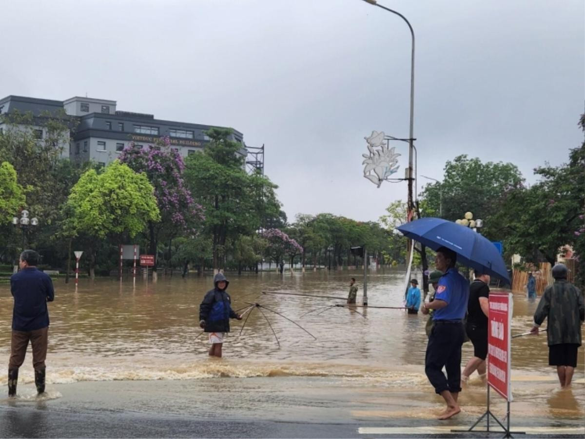 Mưa lớn khiến đường phố ngập 'thành sông', người dân mang vó, nơm ra giữa ngã tư đường bắt cá Ảnh 2