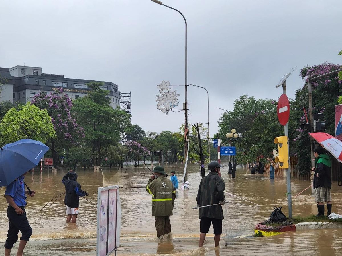 Mưa lớn khiến đường phố ngập 'thành sông', người dân mang vó, nơm ra giữa ngã tư đường bắt cá Ảnh 3