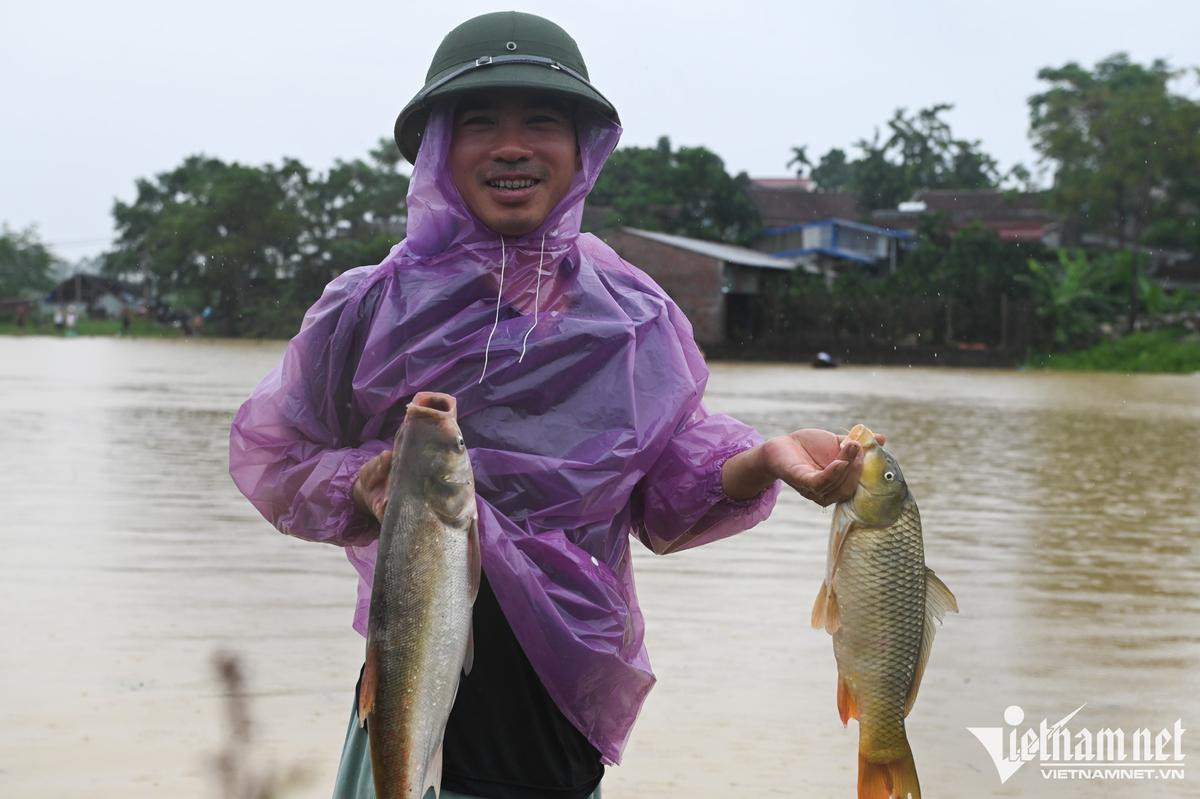 Người dân ngoại thành Hà Nội chèo thuyền trên đường làng, đổ xô đi bắt cá sau mưa lớn Ảnh 8